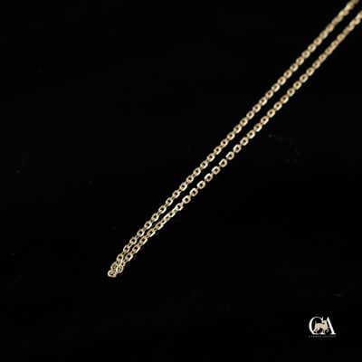 un gros plan d'un collier à chaîne dorée sur fond noir