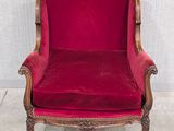 une chaise rouge posée sur un sol blanc, près d'un mur