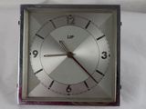 une horloge en argent posée sur un drap blanc