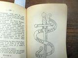 une personne tenant un livre sur lequel figure le dessin d'un serpent