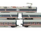 four model trains are lined up on a white surface