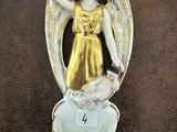 une statue représentant un ange tenant un chien dans un bol