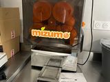 a machine that has oranges in it in a kitchen