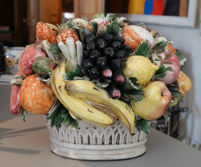 un panier blanc rempli de fruits et de légumes posé sur un comptoir