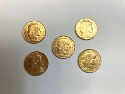 quatre types différents de pièces d'or sur une surface blanche