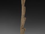 a wooden sculpture of a bird on a branch on a base