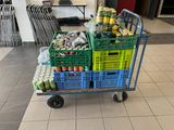 a cart full of sodas and cans on the floor