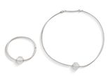 deux bijoux en argent posés sur une surface blanche, sur fond blanc