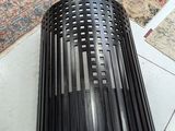 a black trash can sitting on the floor next to a rug