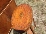 a small wooden table with a mirror on top of it in the grass