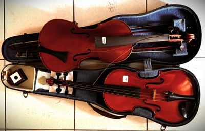 a violin and a violin case sitting on a tile floor