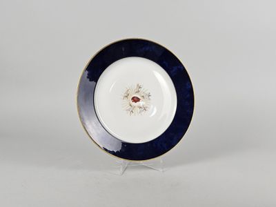 a close up of a plate on a stand on a white surface