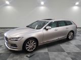 une Volvo break argentée garée sur un sol en carrelage à damier