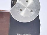 a box with a metal object inside of it on a white surface