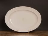 une assiette blanche posée sur une table en bois, sur fond noir