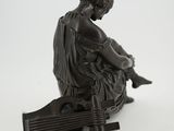 statue of a woman sitting on a bench with a guitar