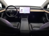 the interior of a tesla vehicle with a laptop on the dashboard