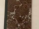 un cahier marbré marron et blanc, surmonté d'un bloc-notes