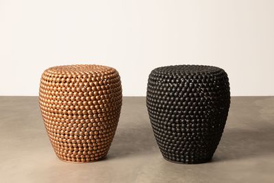 deux tabourets noirs et marron posés sur un sol en béton