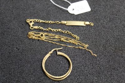 a gold necklace and a gold ring on a table