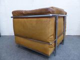 a brown leather chair with a metal frame on the floor