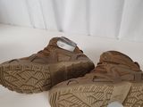 the soles of a pair of brown sneakers are on a white surface