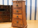 a small wooden chest of drawers next to a small chest of drawers
