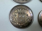 three silver coins sitting on top of each other on top of a table