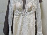 a wedding dress hanging on a hanger next to a coat