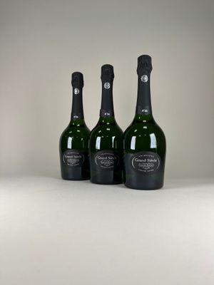 trois bouteilles de champagne posées sur une table blanche