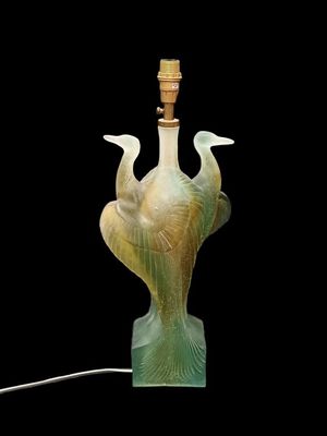 une lampe en verre sur laquelle sont représentés deux oiseaux