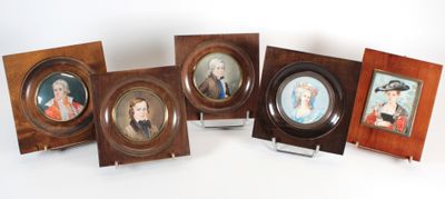 quatre portraits encadrés représentant des personnes sont posés sur une table