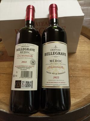 deux bouteilles de vin rouge posées sur un tonneau en bois