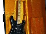a black electric guitar in a case on a white background