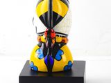 yellow and black statue of a person with a helmet and a sword