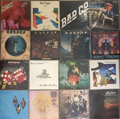 many different album covers on the wall of a room