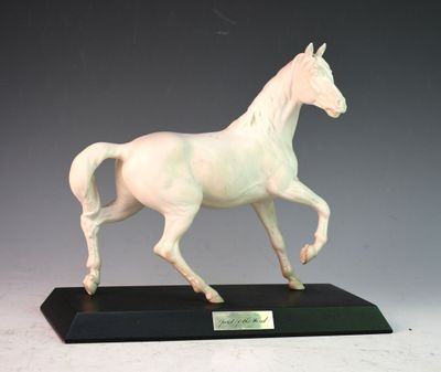 statue d'un cheval blanc au galop, posée sur un socle noir, sur fond gris