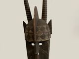 an image of a wooden mask with horns on a white background