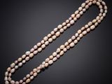 un long collier de perles muni d'un fermoir, sur fond noir