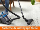 La femme passe l'aspirateur sur la moquette.
