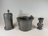 a silver container and two vases sitting on a table