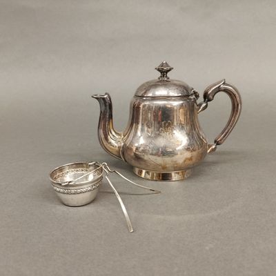une théière en argent avec une cuillère à côté