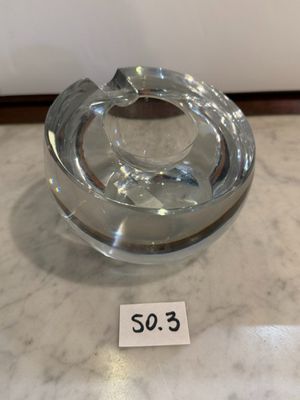 un cendrier en verre posé sur une table en marbre