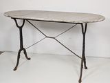 an image of a marble top table with iron legs on a white floor