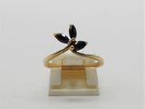 un gros plan d'une bague en or sertie de pierres noires