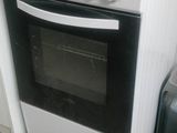 a white stove in a kitchen next to a trash can