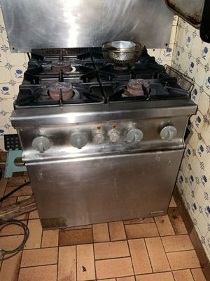 une cuisinière sur laquelle est posée une marmite dans une cuisine
