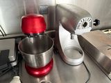 a red mixer and a silver mixer on a kitchen counter