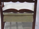 a wooden chair with a white cushion on it