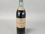 an old bottle of wine sitting on top of a white table
